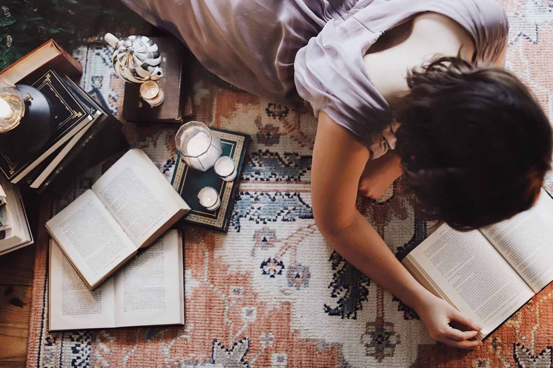 Girl reading surrounded by books